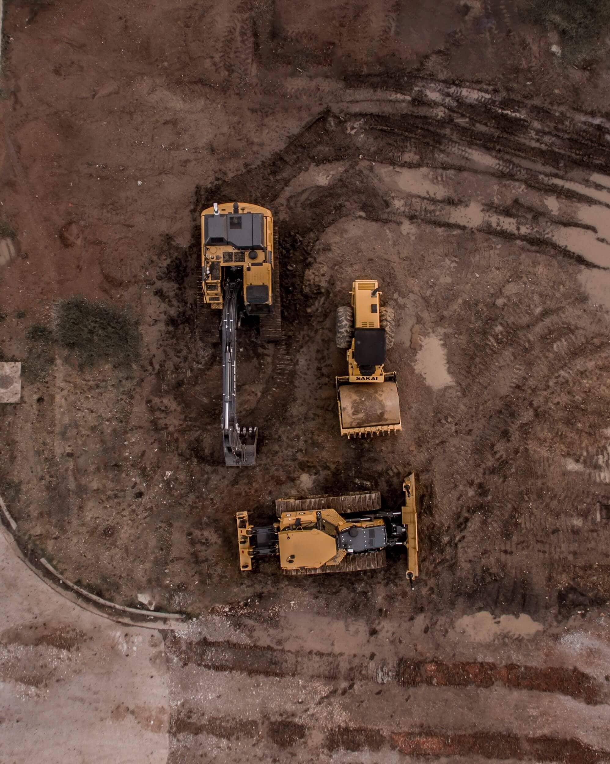 Aerial view of a construction site with excavators, road rollers, and bulldozers